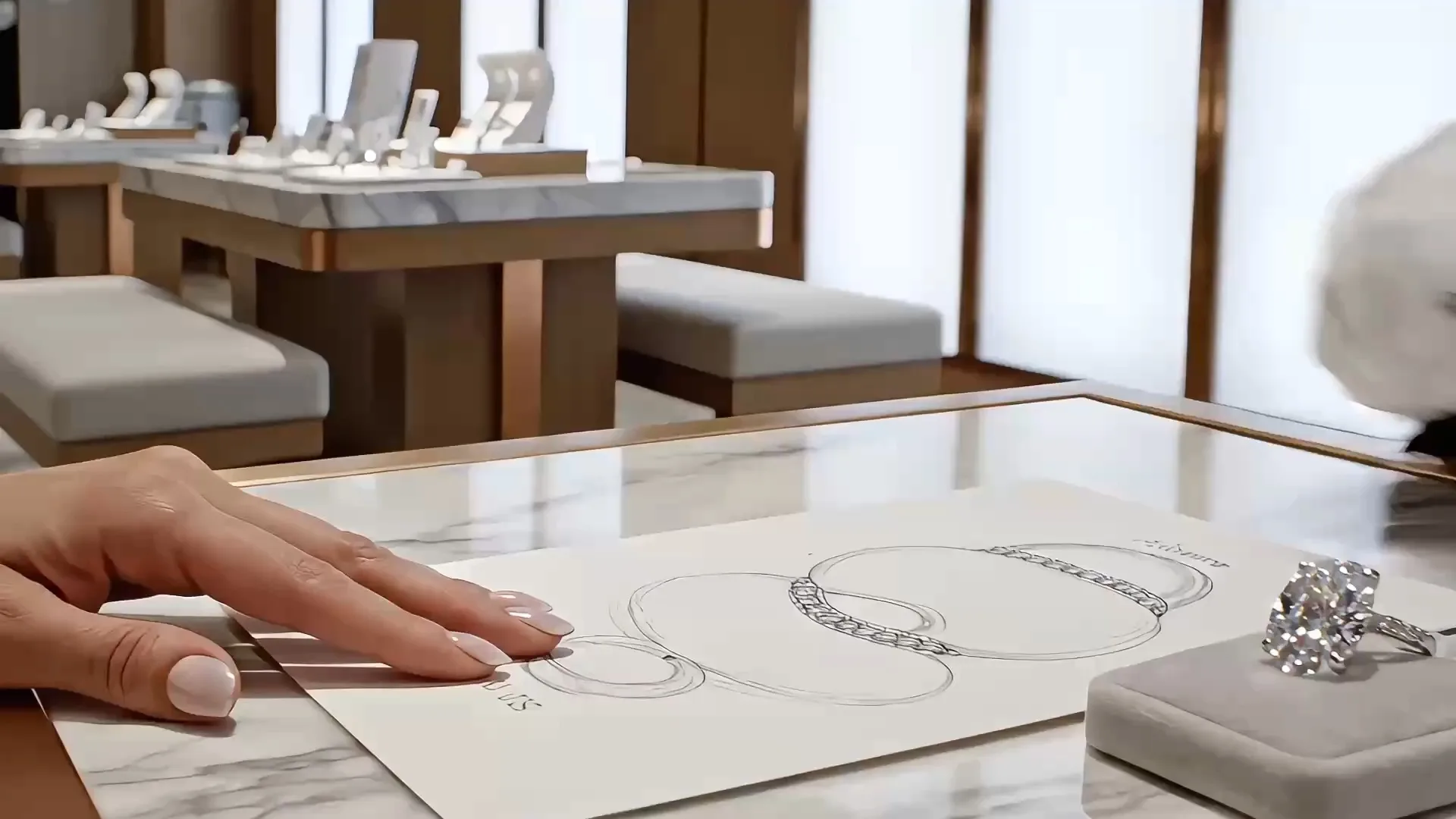 A jeweller sketching a ring design on paper