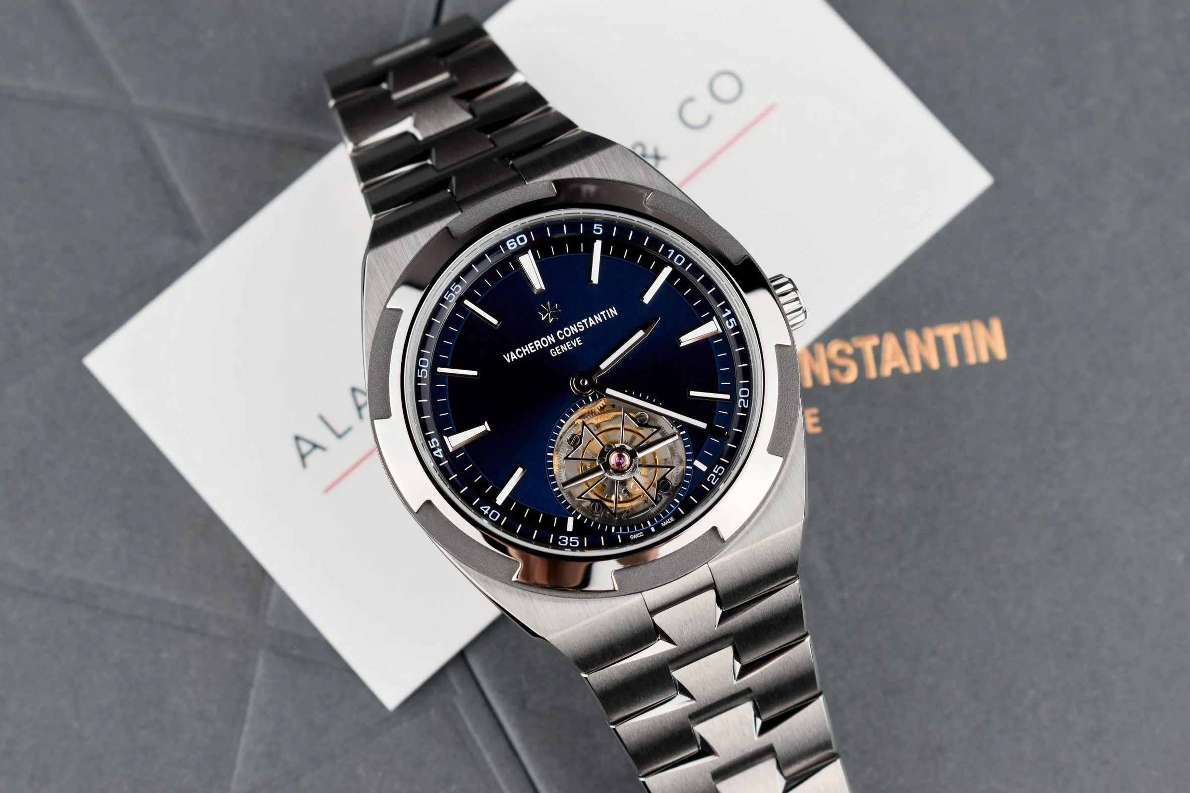 Vacheron Constantin Overseas Tourbillon with a blue dial on a titanium bracelet, resting on an Alan Furman & Co card and its box
